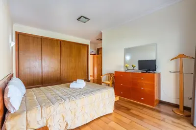 a bedroom with a bed and a dresser and a television at Villa Coute Real in Quarteira