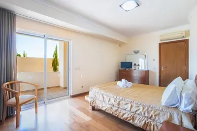 a bedroom with a bed and a sliding glass door at Villa Coute Real in Quarteira