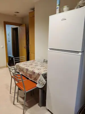a kitchen with a table and a white refrigerator at 2 bedroom top floor apartment in Albufeira in Albufeira