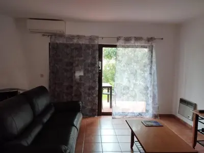 a living room with a couch and a large window at Apartamento São Rafael Holidays in Albufeira