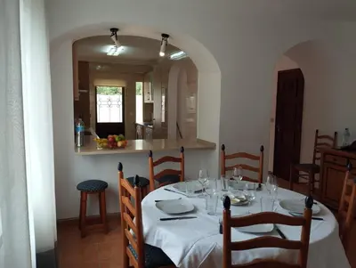 a dining room with a table and a kitchen at Apartamento São Rafael Holidays in Albufeira