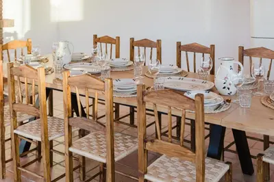 a wooden table with chairs and plates on it at Monte Gerações - Complete House - Heated pool - Typical Algarvian - close to Quinta Lago Vale Lobo and Vilamoura in Almancil