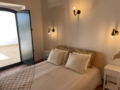 a bedroom with a bed with two pillows and a window at Monte Gerações - Complete House - Heated pool - Typical Algarvian - close to Quinta Lago Vale Lobo and Vilamoura in Almancil
