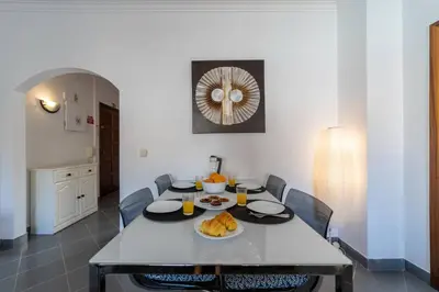 a dining room with a white table and chairs at Garnero Apartment by HelloVacations in Albufeira