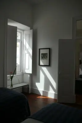 a bedroom with a bed and a window and a door at Casas Adentro in Faro