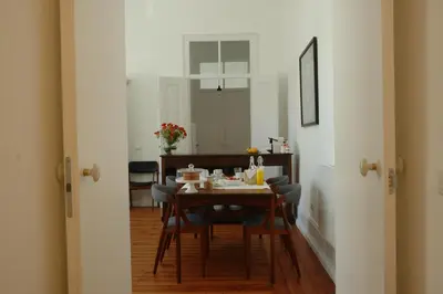 a dining room with a table and chairs and a room with a table at Casas Adentro in Faro
