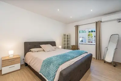 a bedroom with a large bed and a window at Casa da Amélia in Albufeira