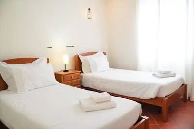 two beds in a room with white sheets and towels at Villa Lydika I in Albufeira
