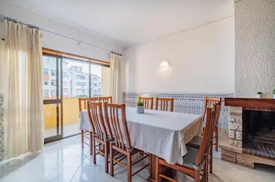 a dining room with a table and chairs and a window at Blue Wave Apartment in Albufeira