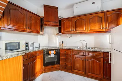 a kitchen with wooden cabinets and a sink at Blue Wave Apartment in Albufeira