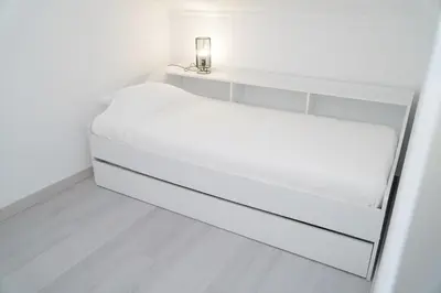a white bed in a white room at Apartamento Bernard in Albufeira