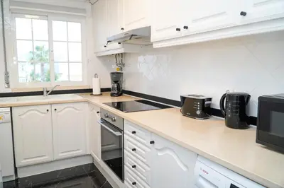 a white kitchen with a sink and a microwave at Apartamento Bernard in Albufeira