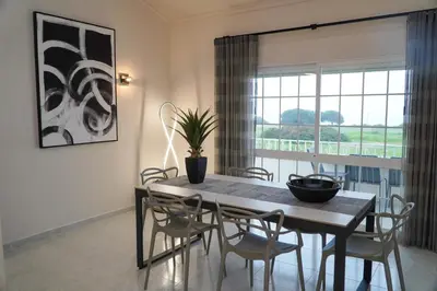a dining room with a table and chairs and a window at Apartamento Bernard in Albufeira