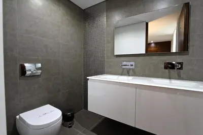 a bathroom with a white toilet and a mirror at Villa Pinheiro CD 84 - Cleverdetails in Vilamoura