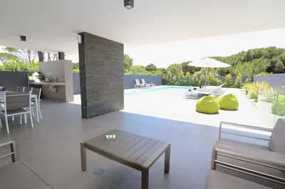 a living room with a table and a pool at Villa Pinheiro CD 84 - Cleverdetails in Vilamoura