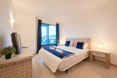 a bedroom with two beds and a large window at Residence Golf Club lovely Ap in Quarteira
