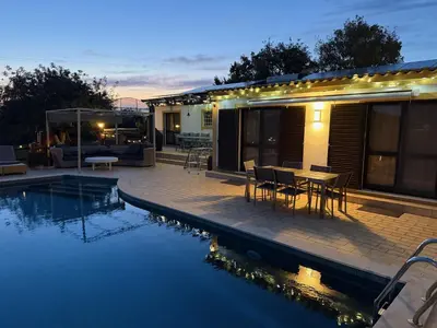 a patio with a table and chairs next to a swimming pool at Casa Tranquility with beautiful heated pool and Jacuzzi! in Loulé