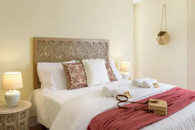 a bedroom with a large bed with two towels on it at Urban Bliss Guesthouse II in Faro