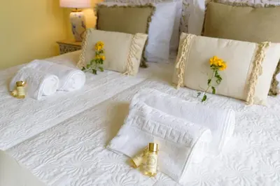 a white bed with towels and flowers on it at Urban Bliss Guesthouse II in Faro