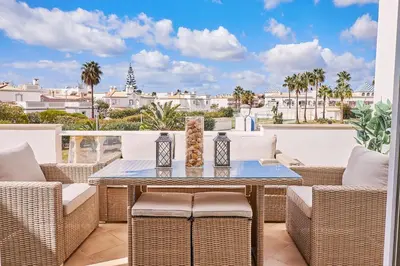 a patio with wicker chairs and a table on a balcony at Apartment O Monte mit Pool in Guia