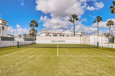 a tennis court in front of a building at Apartment O Monte mit Pool in Guia