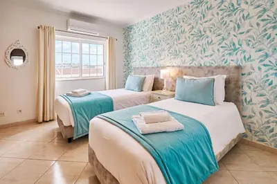 two beds in a room with blue and green wallpaper at Apartment O Monte mit Pool in Guia