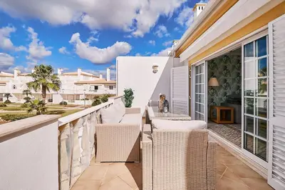 a balcony with wicker chairs and a table at Apartment O Monte mit Pool in Guia