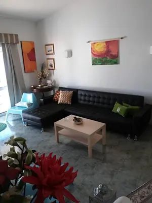 a living room with a black couch and a table at Villa Quica, heated pool in Albufeira