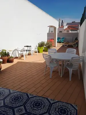 a patio with a table and chairs on a roof at Villa Quica, heated pool in Albufeira