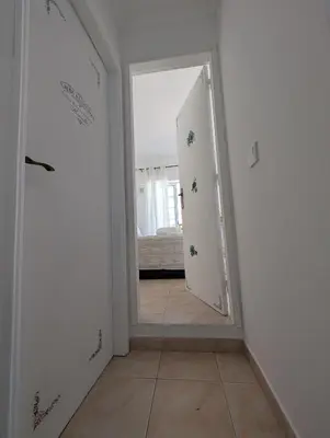 a hallway with a mirror and a room with a bed at Grand Studio 31 in Faro