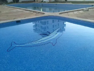 a shark swimming in a large swimming pool at Peixe and Barco Studio's in Vilamoura