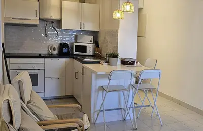 a kitchen with a table and chairs and a microwave at Peixe and Barco Studio's in Vilamoura