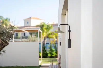 a door with a light on the side of a house at Modern Sea View Villa, Heated Pool,Rooftop Jacuzzi Outdoor Kitchen 12min faro Airport in Santa Bárbara de Nexe