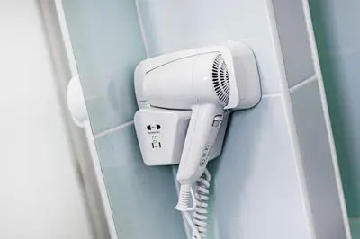 a white hairdryer hanging on a wall at Studio avec vue mer et piscine Algarve Portugal in Albufeira