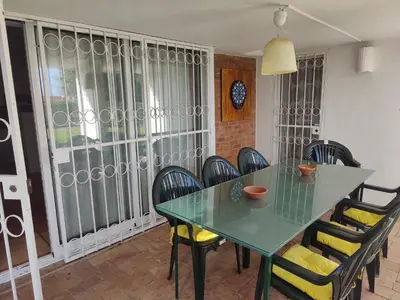 a dining room with a green table and chairs at Casa do Cedro in Albufeira