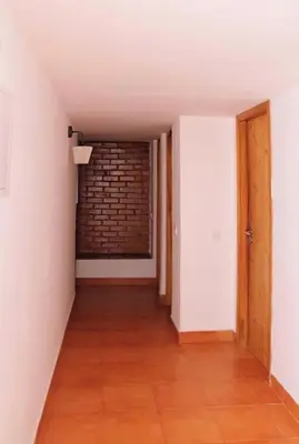 an empty hallway with a brick wall and a door at Casa do Cedro in Albufeira