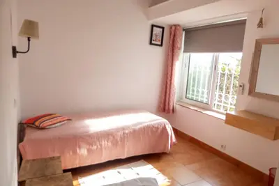 a bedroom with a bed and a window at Casa do Cedro in Albufeira