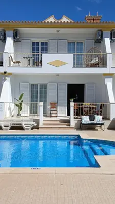 a table with an umbrella next to a pool at Villa Martina in Albufeira