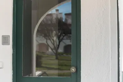 a green door with a reflection of a tree at LovelyStay - Green Oasis Villa in Vilamoura