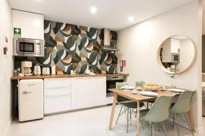 a kitchen with a table with chairs and a microwave at Villa 41 - Private Studios Faro Airport, Beach and City Center in Faro