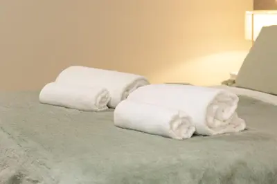 two stacks of towels on top of a bed at Villa 41 - Private Studios Faro Airport, Beach and City Center in Faro