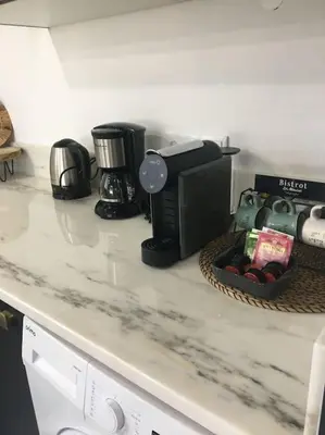a kitchen counter with a coffee maker and a basket on it at Casa Herdeiro in Faro