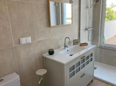 a bathroom with a sink and a mirror and a toilet at Casa Herdeiro in Faro