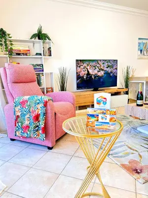 a living room with a pink couch and a table at Golden Palm Condo by BeCherish in Albufeira