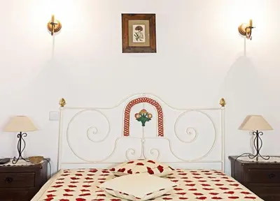 a white bed with a red and white headboard in a bedroom at Monte dos Avós in Querença