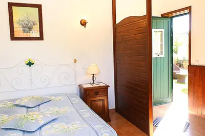 a bedroom with a bed and a table and a door at Monte dos Avós in Querença
