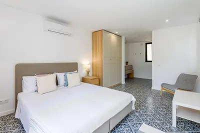 a bedroom with a large white bed and a desk at Casa dos Sonhos, Vale do Lobo in Almancil