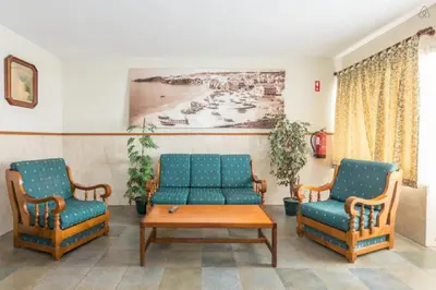 a living room with two chairs and a couch and a table at Residencial Capri by Umbral in Albufeira
