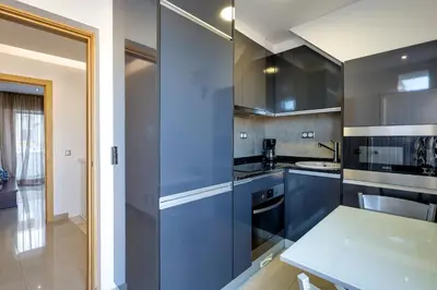 a kitchen with blue cabinets and a table at Casa Maguy in Albufeira