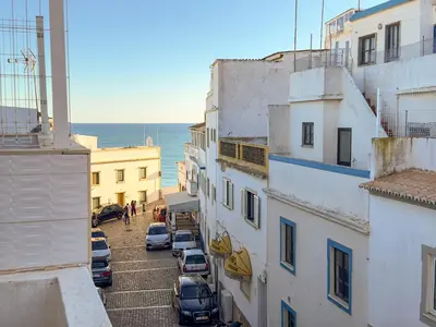 a view of a street with cars parked between buildings at Casa Maguy in Albufeira